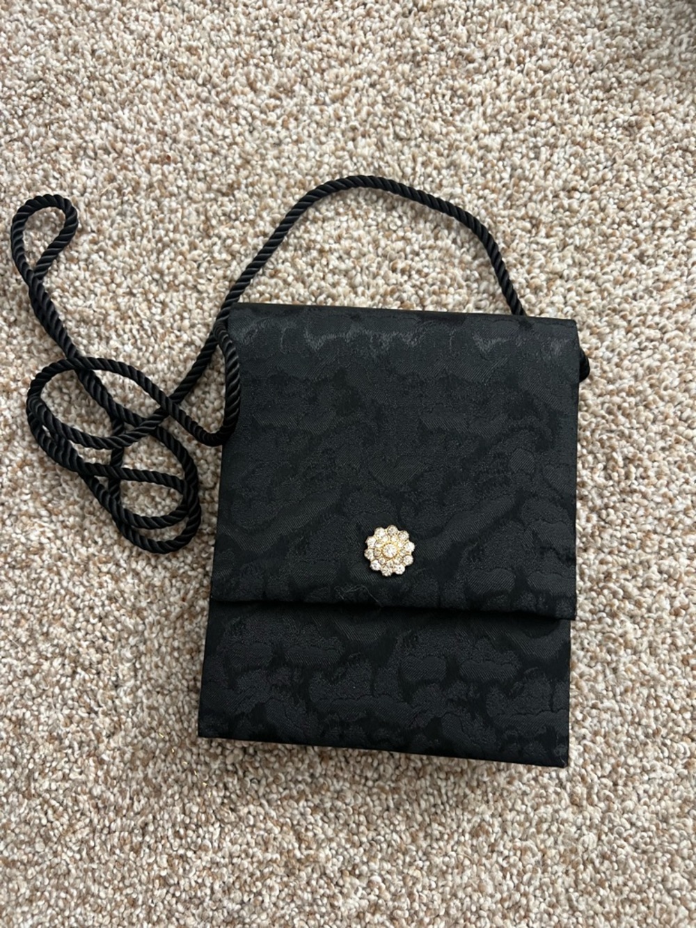 NWOT vintage black brocade floral handbag with strap. Jewel on front